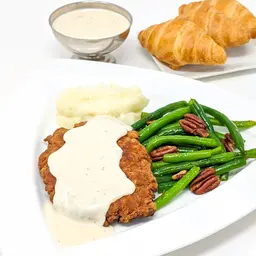 Country fried steak, green beans, mashed potatoes, gravy, and croissants