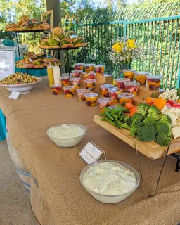 Catering spread with sandwiches, vegetables, homemade ranch, and fruit